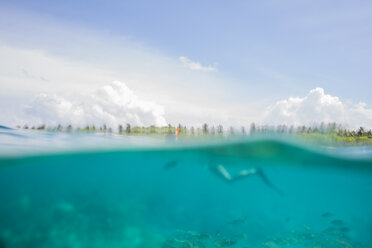 Maldives, split shot of woman snorkeling - ZEF15248