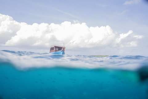Malediven, Split Shot von Boot auf Wasser, lizenzfreies Stockfoto
