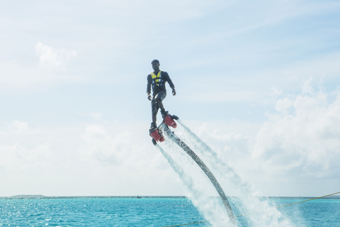 Malediven, Mann auf Flyboard über dem Meer, lizenzfreies Stockfoto