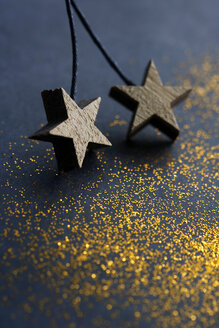Hölzerne Sterne auf dunklem Hintergrund mit goldenem Glitter - HSTF00060