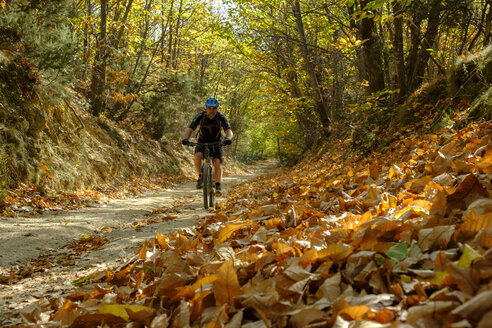 Italien, Ligurien, Finale Ligure, Mountainbiker in einer Schlucht im Herbst - LBF01864