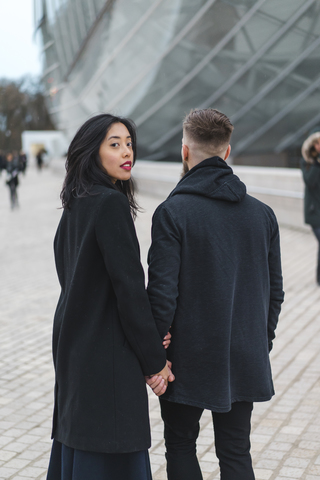 Frankreich, Paris, Porträt einer jungen Frau Hand in Hand mit ihrem Freund, lizenzfreies Stockfoto