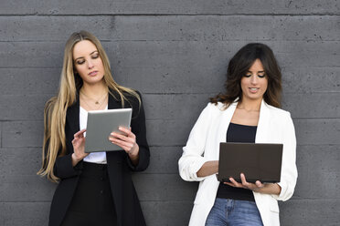 Two businesswomen using tablet and laptop - JSMF00136