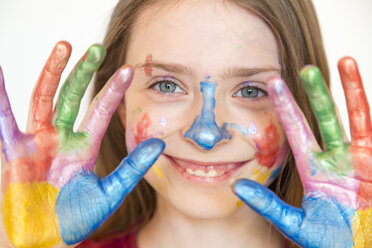 Porträt eines lächelnden Mädchens mit Fingermalfarben an den Händen - SARF03618