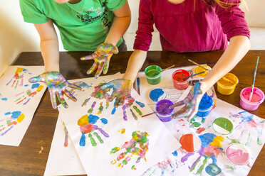 Girl and boy playing with finger paint, hand prints - SARF03624