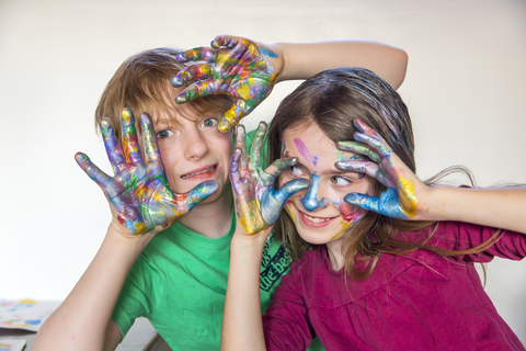 Boy and girl, finger paint on hands stock photo