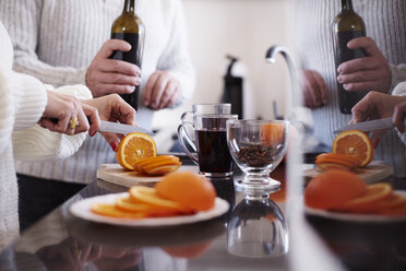 Frau schneidet eine Orange für Glühwein - ABIF00199