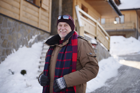 Portrait of smiling senior man in mountain village in winter stock photo