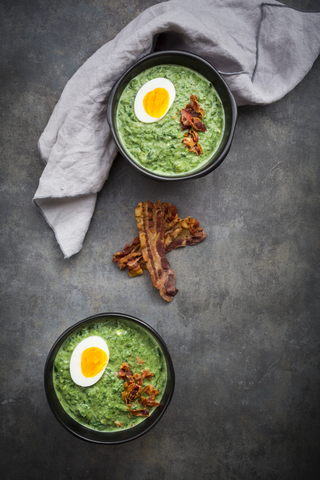 Cream of spinach soup with egg and bacon stock photo