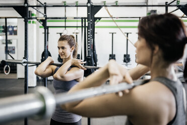 Zwei junge Frauen beim Gewichtheben im Fitnessstudio - FOLF00405