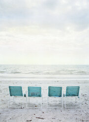 Four empty folding chairs on beach - FOLF00505