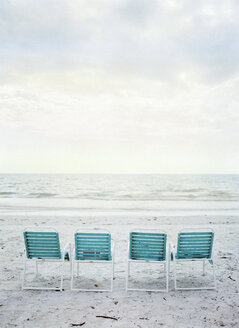 Vier leere Klappstühle am Strand - FOLF00505