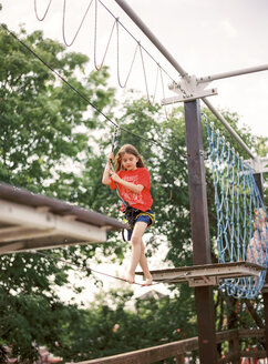 Junge läuft auf einem Seil im Abenteuerpark - FOLF00521