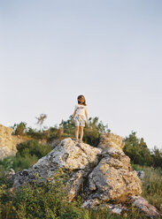 Junge steht auf einem Felsen und betrachtet die Aussicht - FOLF00523