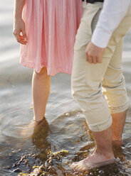 Couple standing barefoot in water - FOLF00565