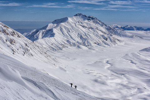 Italien, Abruzzen, Gran Sasso e Monti della Laga, Wanderer auf der Hochebene des Campo Imperatore im Winter, lizenzfreies Stockfoto