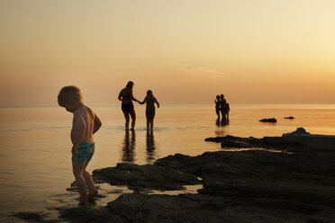 Junge mit Familie am Strand in der Abenddämmerung - FOLF00731