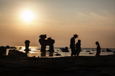 Silhouette von Mutter und Kindern am Strand bei Sonnenuntergang - FOLF00733