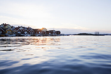 Häuser und Motorboote am Meer bei Sonnenuntergang - FOLF00741