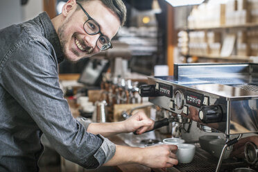 Lächelnder Barista beim Kaffeekochen - FOLF00767