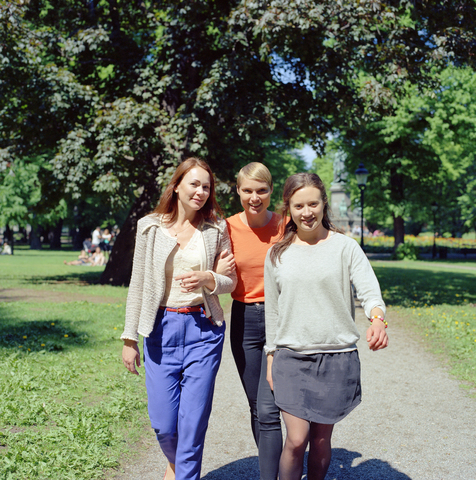 Drei Frauen gehen durch einen Park, lizenzfreies Stockfoto