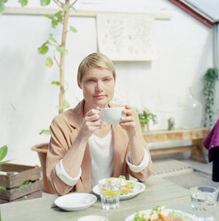 Mid adult woman holding cup of coffee - FOLF00825