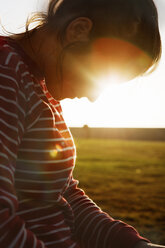 Back lit mid adult woman looking down - FOLF00833