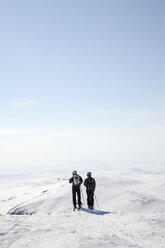 Rückansicht von Männern im mittleren Erwachsenenalter mit Blick auf die Berge im Winter - FOLF00854