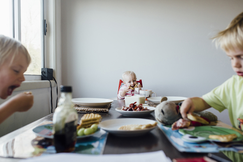 Geschwister beim Frühstück am Tisch, lizenzfreies Stockfoto