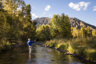 Rear view of man fishing in stream - CAVF28556