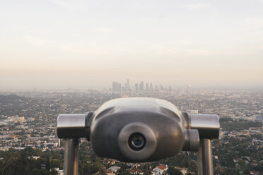 Coin-operated binoculars overlooking cityscape against sky - CAVF28622