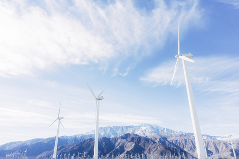 Windturbinen am felsigen Berg gegen bewölkten Himmel, lizenzfreies Stockfoto