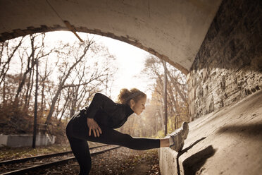Frau trainiert im Tunnel an der Bahnstrecke - CAVF28666