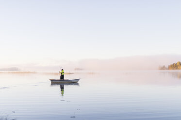 Junger Mann beim Angeln im See bei Sonnenuntergang - FOLF01129