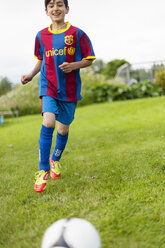 Junge in Sporttrikot läuft auf Ball zu - FOLF01135