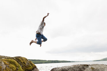 Teenage boy jumping from rocks - FOLF01177