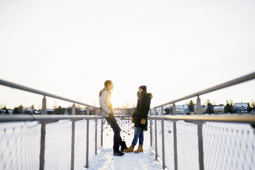 Junges Paar steht von Angesicht zu Angesicht auf einer Fußgängerbrücke - FOLF01198