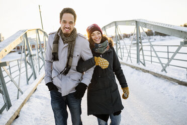 Junges Paar beim Spaziergang auf einer Fußgängerbrücke im Winter - FOLF01202