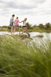 Teenager-Mädchen gehen auf Felsen im Wasser - FOLF01207