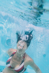 Woman wearing bikini diving in swimming pool - FOLF01232