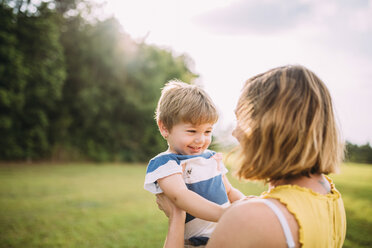 Happy mother lifting son at park - CAVF28723