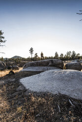 Full length of hiker standing on rock against clear sky - CAVF28742