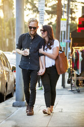 Happy couple walking on sidewalk - CAVF28748