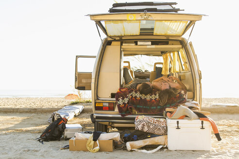 Junges Paar im Minivan liegend im Sommerurlaub am San Onofre State Beach - CAVF28812
