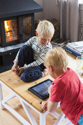 Boys playing with digital tablet at home - FOLF01283