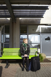 Woman sitting on bench at the airport - FOLF01301