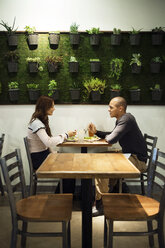 Seitenansicht eines Paares, das sich beim Essen im Restaurant unterhält - CAVF28833