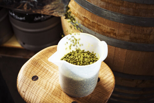 High angle view of pellets hops been poured in beaker at brewery - CAVF28853