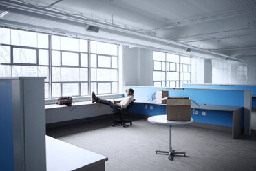 Businessman using mobile phone while relaxing in office - CAVF28877