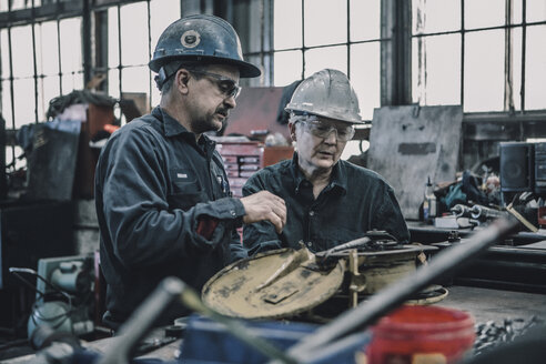 Mitarbeiter bei der Arbeit am Tisch in der Metallindustrie - CAVF28962